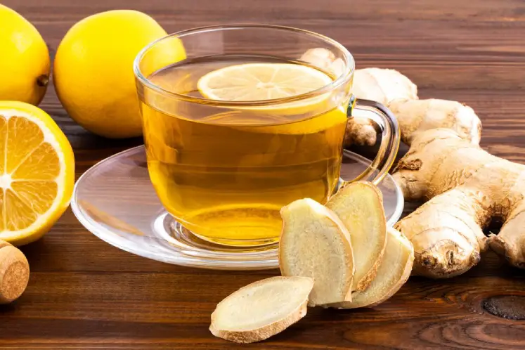 A cup of ginger tea with fresh ginger slices, representing a soothing and metabolism-boosting detox drink.