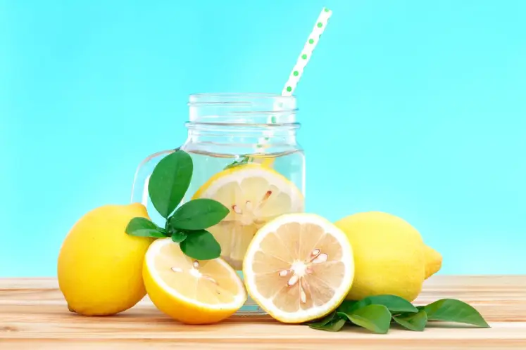 A glass of lemon water with fresh lemon slices, representing a cleansing and refreshing detox drink.