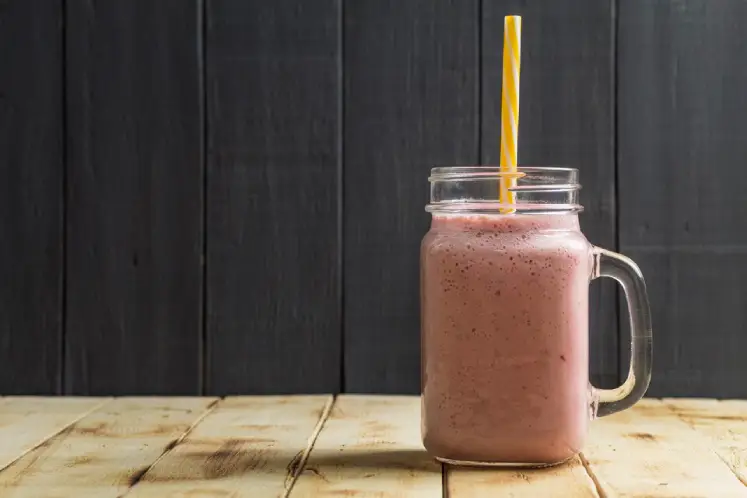 A glass filled with a creamy smoothie made with vanilla protein powder, almond butter, banana, spinach, and almond milk, representing the Protein Powerhouse Smoothie recipe.