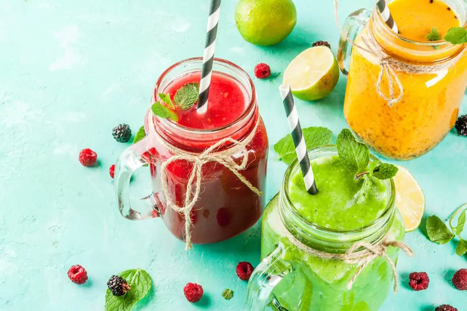 Assortment of colorful smoothie recipes in glasses with fresh fruits and vegetables, representing healthy weight loss recipes.