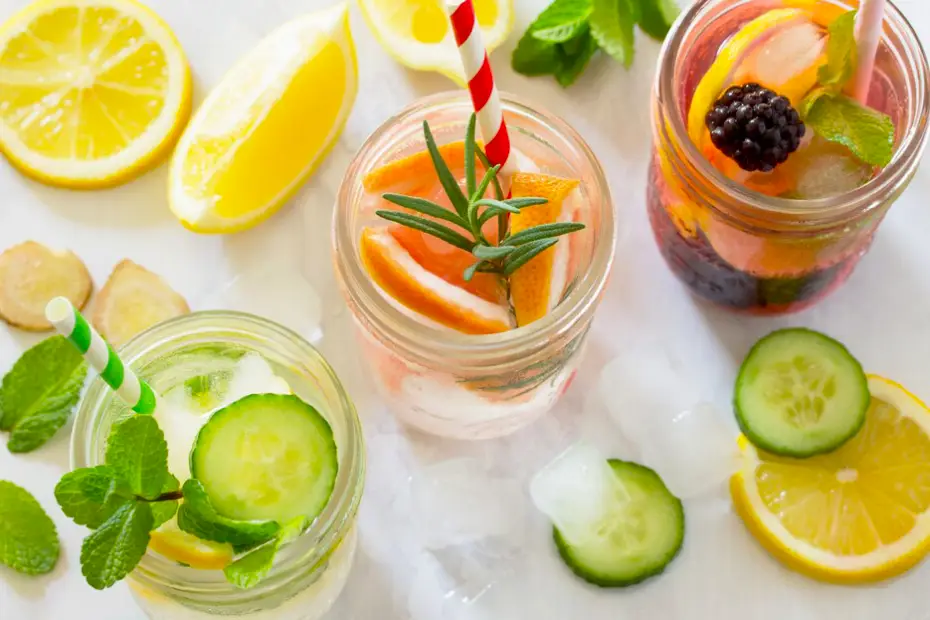 A selection of colorful detox waters infused in glass pitchers with fresh fruits and herbs.